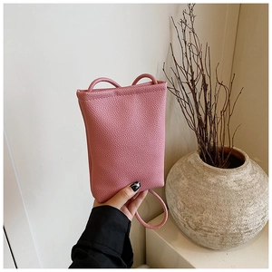 Detail of pink lychee textured leather mini phone bag with minimalist shoulder strap