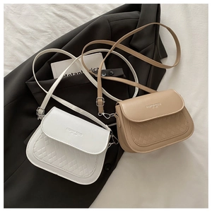 Close-up of white and beige woven texture crossbody bags with gold logo detail