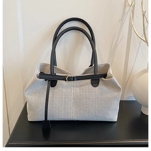 Detail of canvas texture and black leather accents on a retro large tote bag