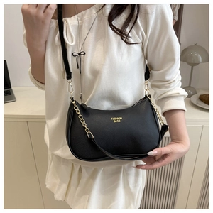 Detail of black hobo bag featuring litchi texture, chunky gold chain and brand logo
