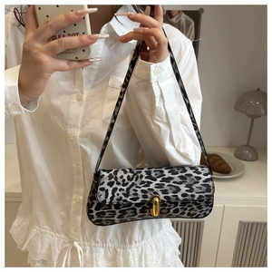 Detail of grey leopard print shoulder bag featuring a sleek golden buckle and metal clasp