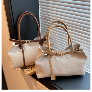 Detailed macro view of textured linen tote bag with leather straps and decorative buckle