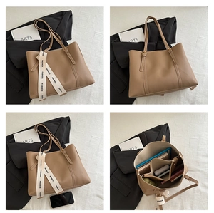 Detail view of large brown leather tote bag with internal compartments and silk ribbon