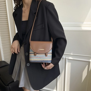 Sac bandoulière en paille à rayures arc-en-ciel avec rabat en cuir sur un mannequin