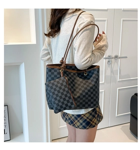 Detailed view of checkered tote bag with brown leather straps and matching small pouch