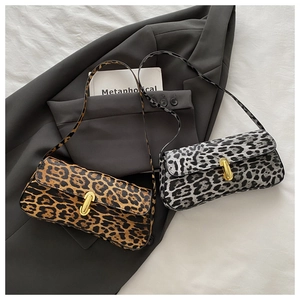 Detailopname van baguette-tassen met luipaardprint in bruin en grijs met gouden gespen