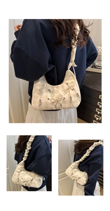 Detail of hobo shoulder bag with plaid pattern, bows, and ruffled cloud strap