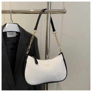 Detail shot of white litchi pattern leather underarm bag with gold chain and black trim