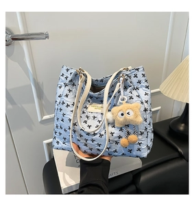 Détail du cabas bleu clair à motifs de nœuds avec pendentif ours jaune mignon