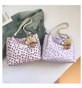 Détail de grands sacs fourre-tout avec motifs nœuds et porte-clés en peluche