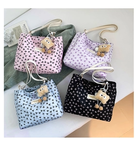 Vue à plat de sacs cabas en quatre couleurs avec motifs nœuds et breloques ours peluche