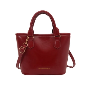 Sac seau rouge brillant en cuir avec détails dorés et bandoulière amovible
