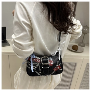 Close-up of Y2K black shoulder bag with silver chains, star studs and ribbon details