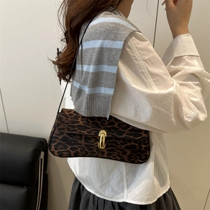 Leopard-Unterachseltasche mit goldener Schließe, am Modell in stilvoller Umgebung