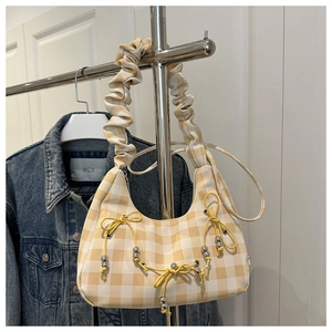 Detail of yellow plaid hobo bag featuring ruched cloud handle and silver bead charms