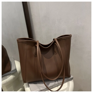 Close-up of coffee brown tote bag showing vertical stitching and high-quality synthetic leather