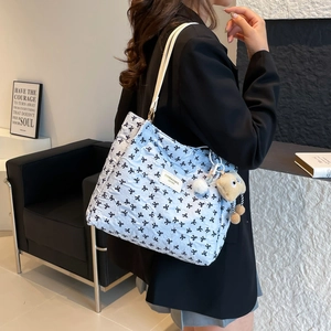 Grand sac cabas matelassé avec motifs de nœuds noirs et pendentif d'ours en peluche