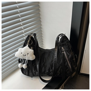 Detail of black pleated shoulder bag featuring a cute white cloud plush pendant