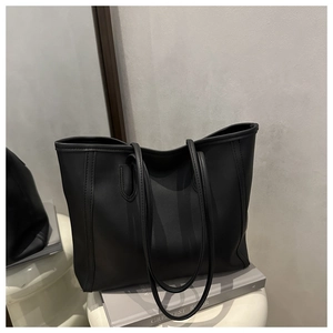Close-up of minimalist black tote bag featuring matte finish and refined stitching details