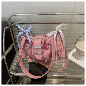 Detailed shot of pink Y2K shoulder bag with metal chains, star charms and ribbon bows