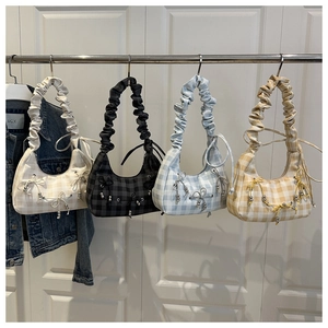 Detail of four checkered hobo bags in assorted colors with ruffled handles and bows
