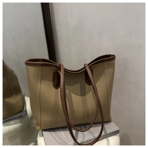 Detail of khaki tote bag with dark brown straps and vertical stitching on the exterior