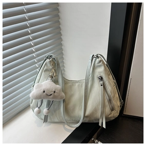 Detail view of a soft pleated mint green hobo bag featuring vertical zipper pockets