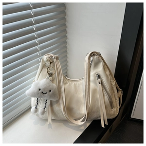 Detail of hobo bag in cream faux leather with long zipper tassels and cloud pendant