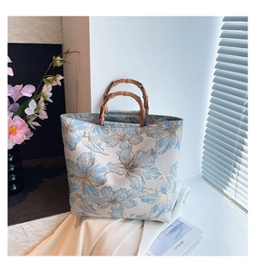 Détail du sac cabas en jacquard floral avec anses en bambou naturel et design chic