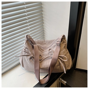 Detail of grey-purple nylon tote with side bowknot and premium metal zipper closure