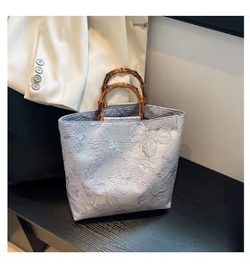 Détails du tissu jacquard floral et des poignées en bambou du sac fourre-tout