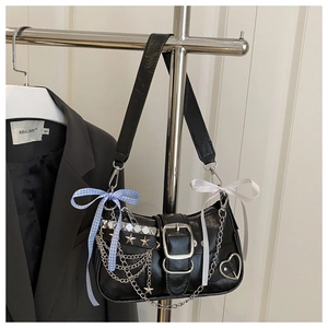 Detail of Y2K black hobo bag with metal chains, star rivets and blue plaid bow charm