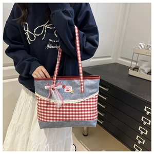 Close-up of a denim and red plaid patchwork tote bag with lace trim and cherry detail