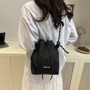 Sac seau en nylon noir avec cordon de serrage et bandoulière tissée contrastante