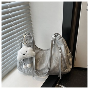 Detail of silver metallic tote bag featuring pleated texture and cute cloud charm