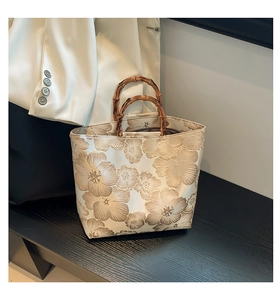 Détail du sac cabas en jacquard élégant avec motifs floraux et poignées en bambou