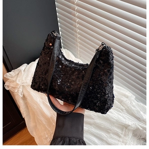 Close-up of black sequin fabric texture and silver zipper on the trendy hobo shoulder bag