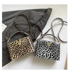 Detail of leopard print tote bags with gold V-logo in brown and black-white versions