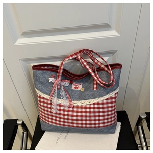 Detail of contrast plaid tote bag with lace trim, cherry patch and bow decoration