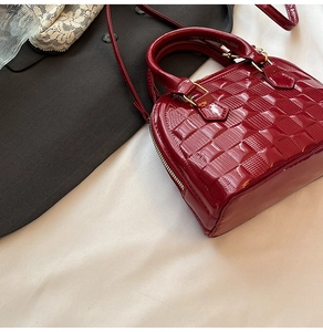 Detail view of burgundy patent leather shell bag with quilted checkered pattern