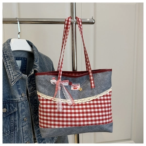 Close-up of red and white plaid denim tote bag featuring lace bow and cherry patch