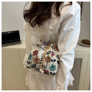 Detailed shot of ethnic jacquard bucket bag with floral patterns and pearl drawstring