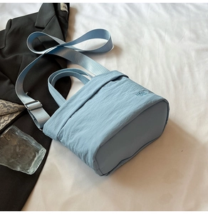 Détail du sac en nylon bleu clair avec broderie RAH TOP et bandoulière assortie