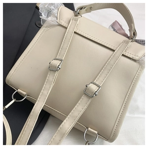 Détail des bretelles réglables et de la dentelle sur un sac à dos en cuir crème