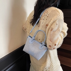 Light blue woven straw bucket bag with FASHION patch, stylish dual-handle crossbody style