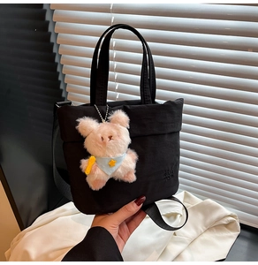 Détail du sac bandoulière noir en nylon avec logo et charmant animal en peluche rose