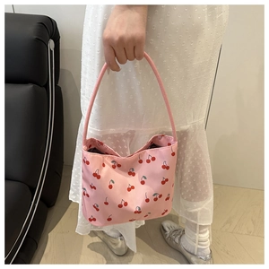 Detail of pink shoulder bag with red cherry prints and smooth fabric texture