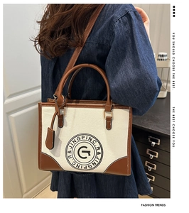 Detail of vintage canvas tote with leather trim and round logo in a cozy interior
