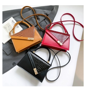 Drei elegante Handtaschen mit Krokodilmuster in Braun, Rot und Schwarz mit Drehverschluss