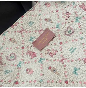 Gros plan sur un sac cabas en seersucker avec motifs floraux et étiquette en cuir